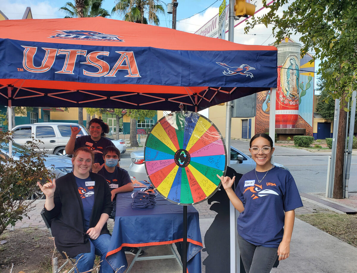 UTSA students offer prizes and games at a tent outside the Westside Community Center.