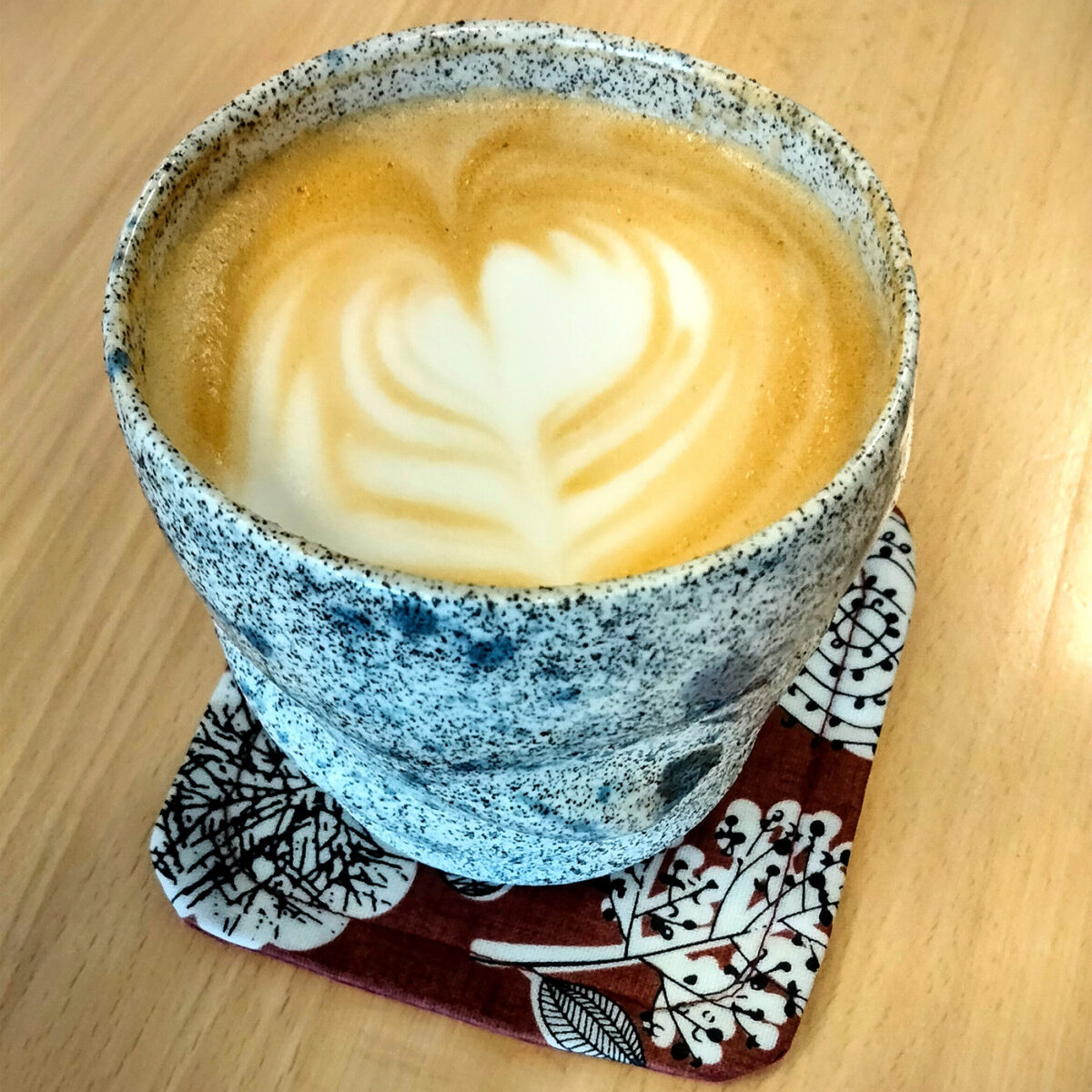 A lavender latte in a textured ceramic mug