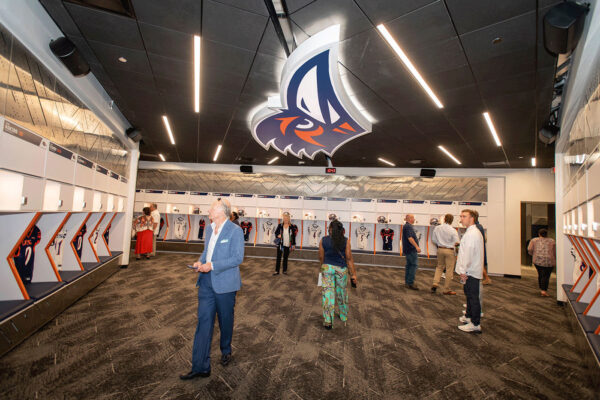 Vistiors gaze at the football team's new locker room in the Roadrunner Athletics Center of Excellence.