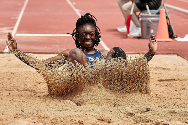 Oreoluwa Adamson lands in the sand during the long jump