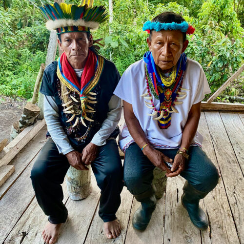 two Indigenous shamans in traditional attire