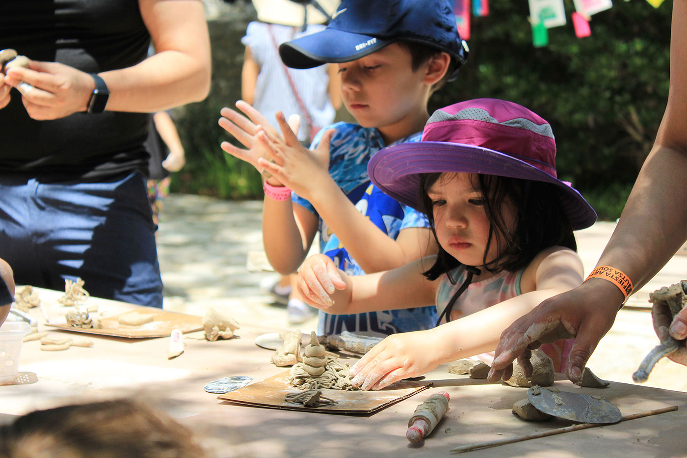 A little girl molds clay