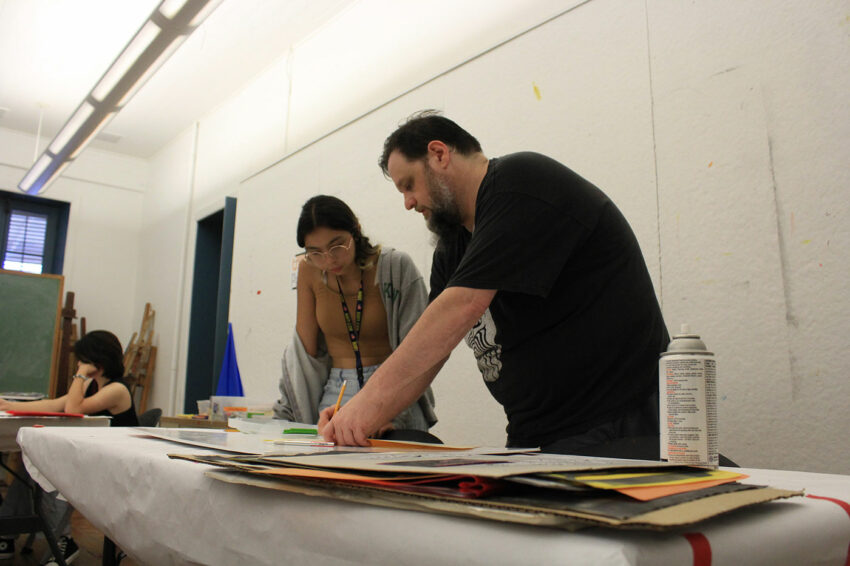 An art educator helps a student with her work.