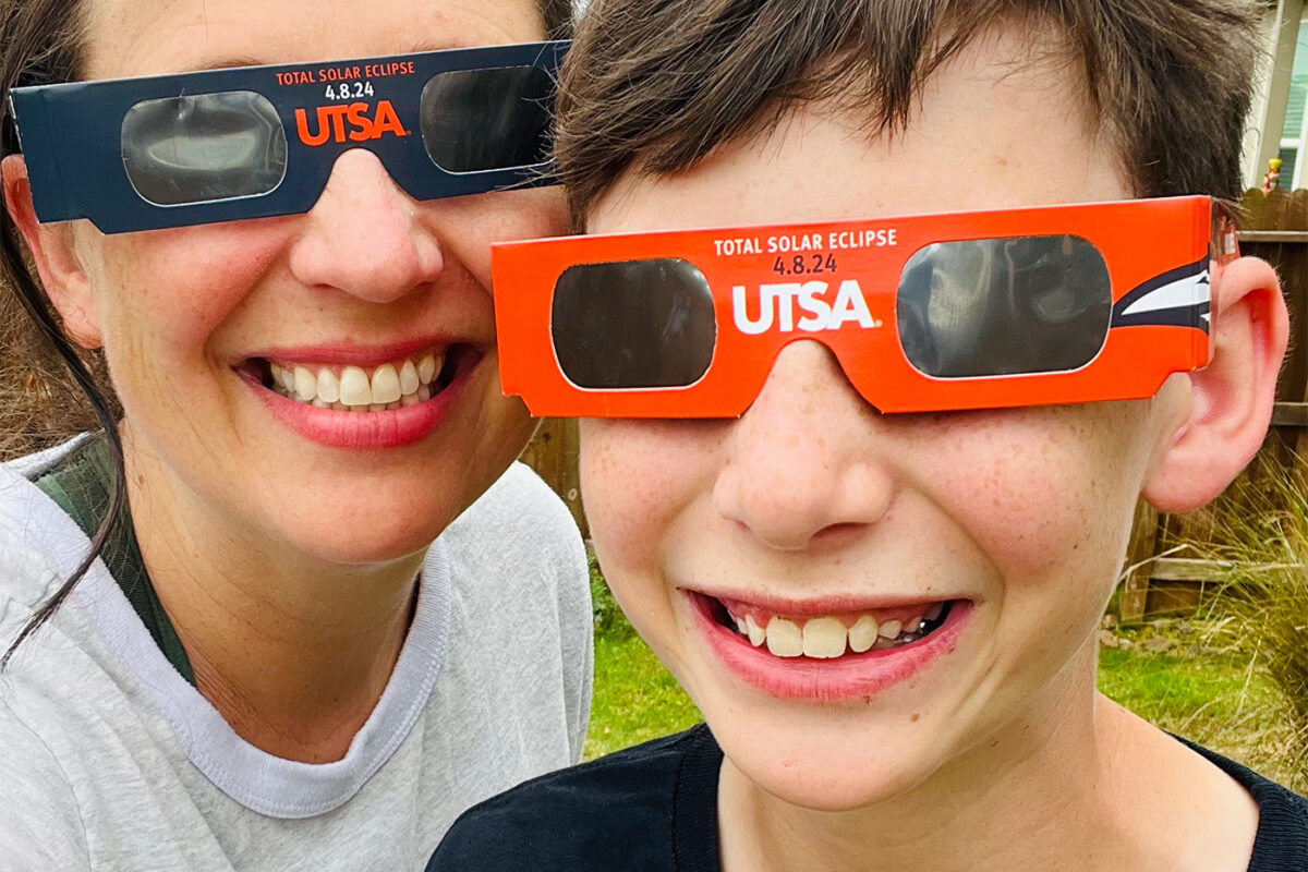 Mother and son pose with their eclipse glasses.