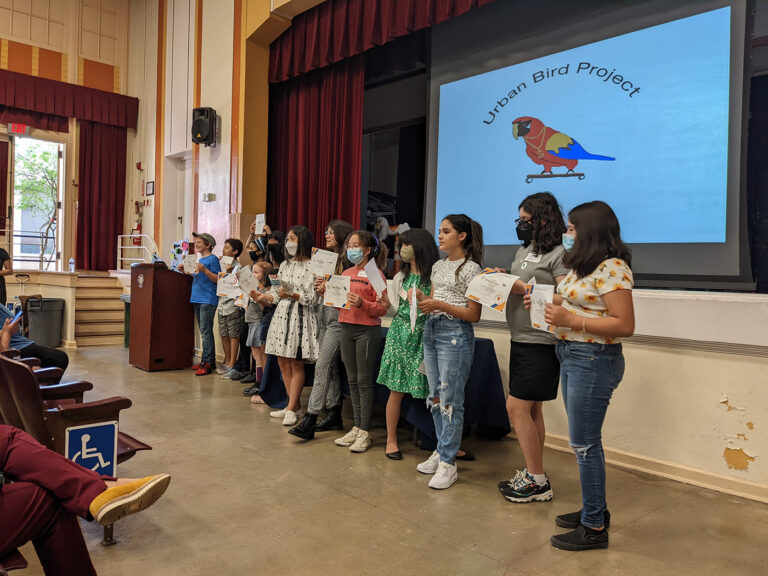 A group of students hold up certificates.