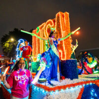 Alondra Castillo holds up glow sticks on UTSA's parade float