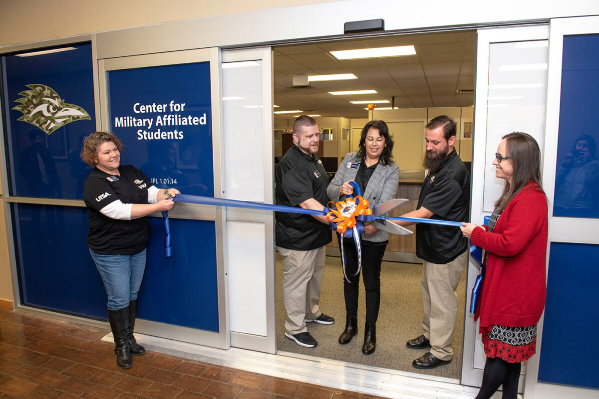 Michael Logan, Lisa Carrington Firmin and William Lansdon cut a ceremonial ribbon