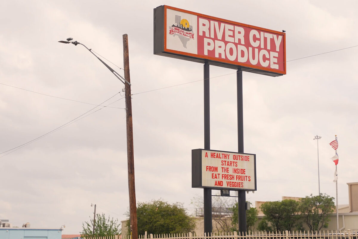 A sign for River City Produce encourages passers-by to eat fruit and vegetables