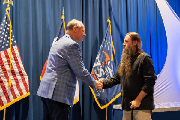 UTSA President Taylor Eighmy shakes hands with William Lansdon