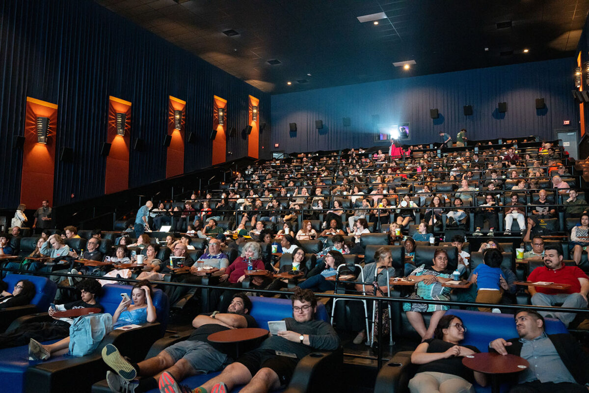 A packed movie theater awaits the student films to begin