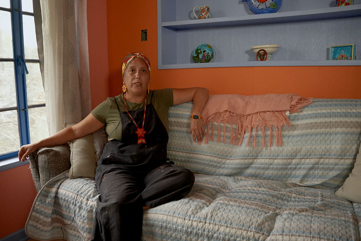 A woman sits on a couch in her living room