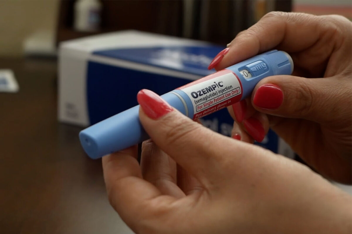 A woman holds an Ozempic pen