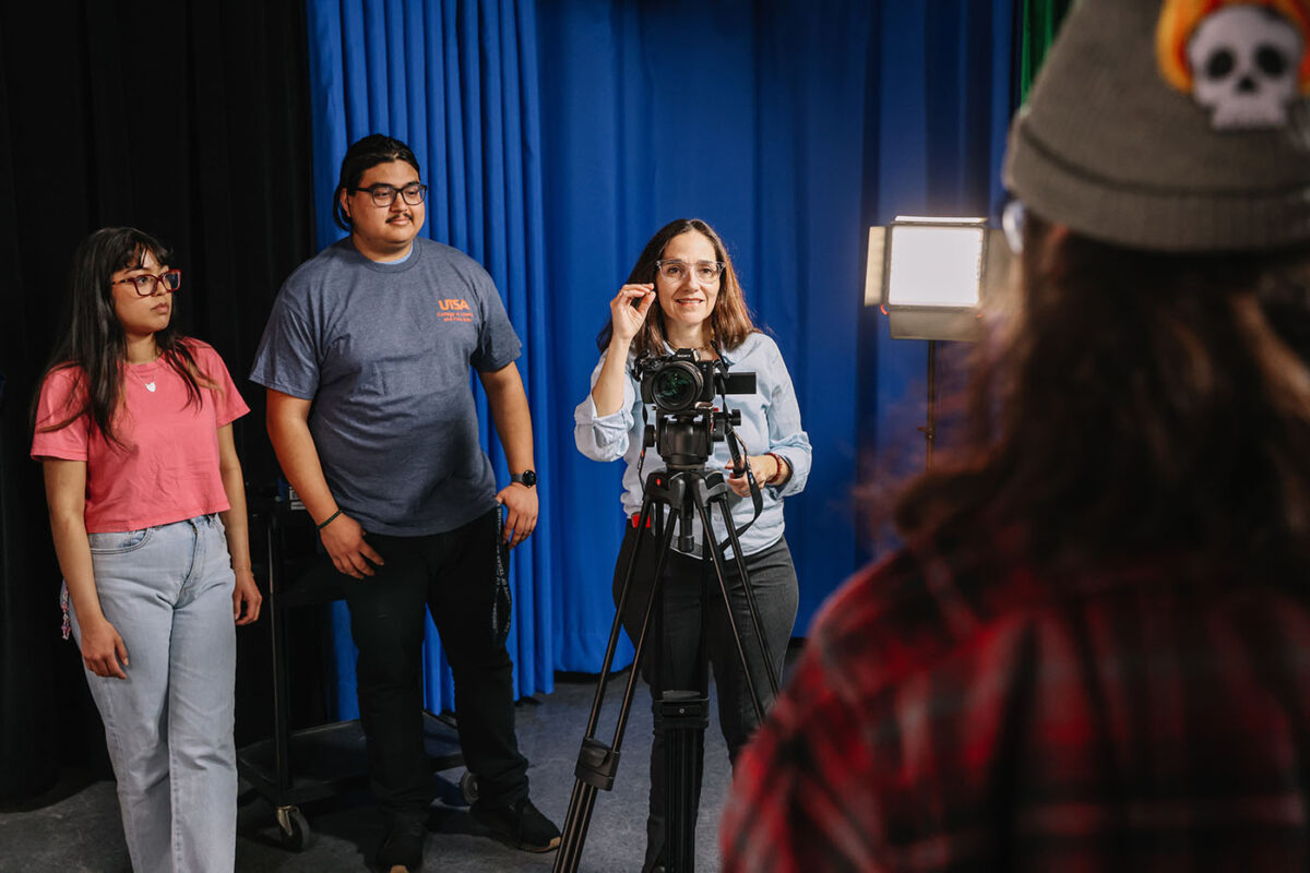 UTSA professor Guillermina Zabala Suarez gives instruction to a student in front of a camera