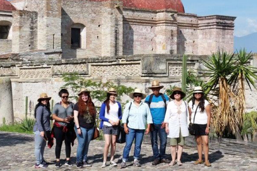 eight people standing in front of a church in Mexico