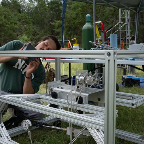 An alumni works on a rocket engine.