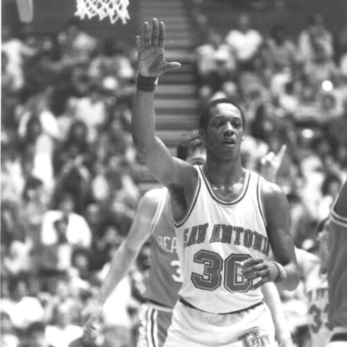 Man stands in front of basketball basket.