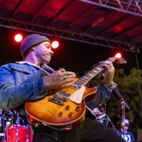 Man strums a guitar.