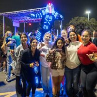 Group of people stand in front of music stage.