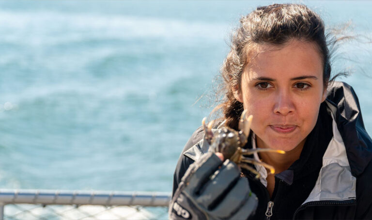 Sarah Gibbens holds a Dungeness crab in her right hand