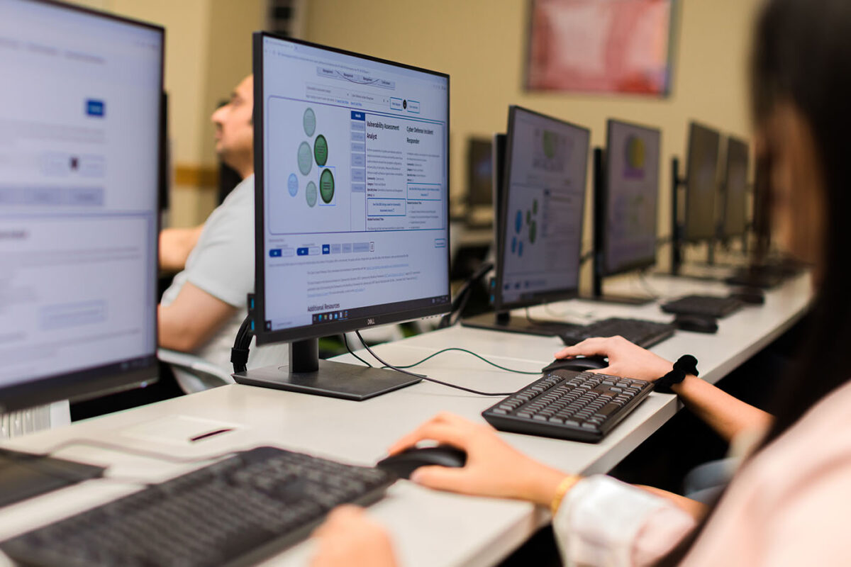 A woman clicks a mouse in a computer lab