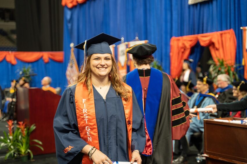 Woman smiles while wearing a cap and gown.