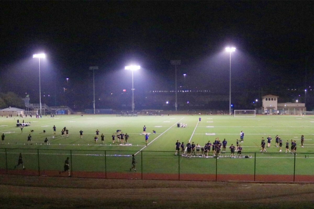 Groups of cadets gather on two recreational fields before sunrise
