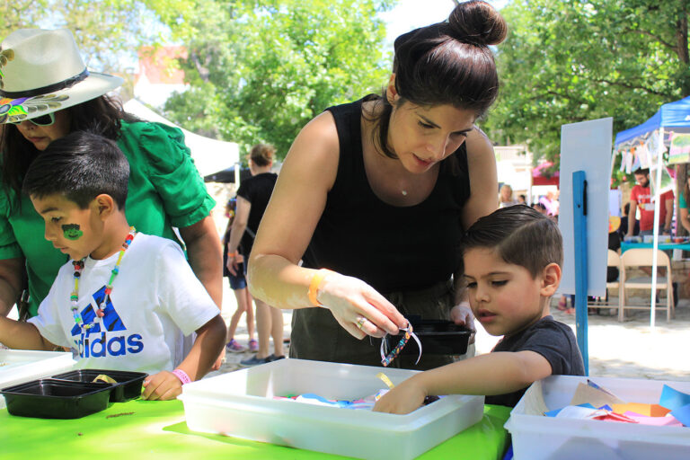 A woman and boy play with a string of beads.