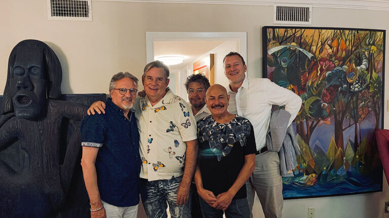 Five men standing together and pose for a photo.