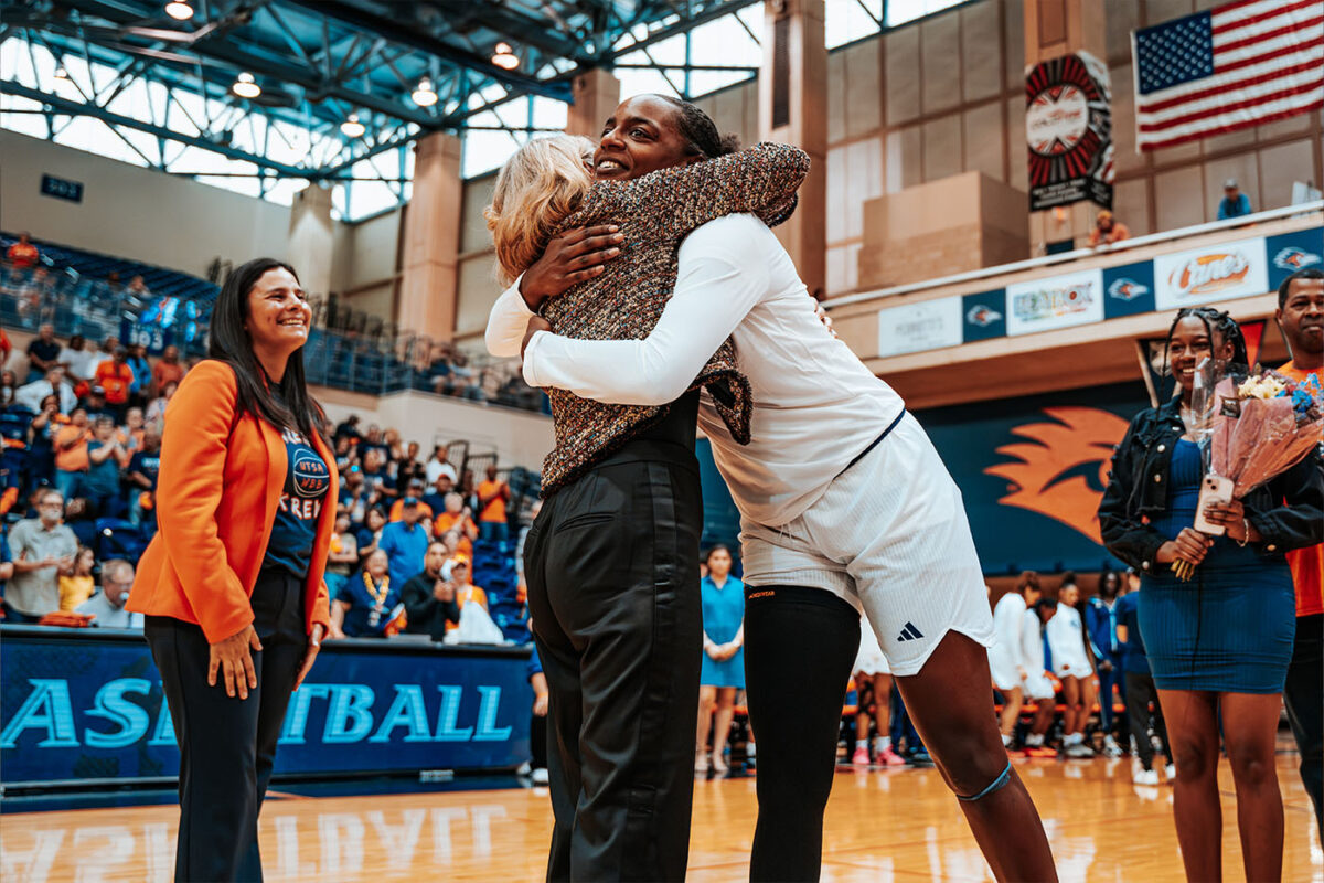Jenkins hugs Aston as Athletic Director Lisa Campos watches on.