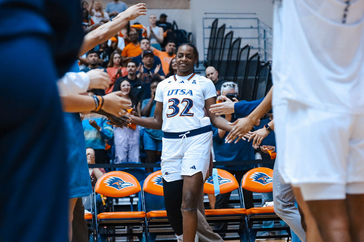 Jenkins slaps hands with her teammates and she walks on the court