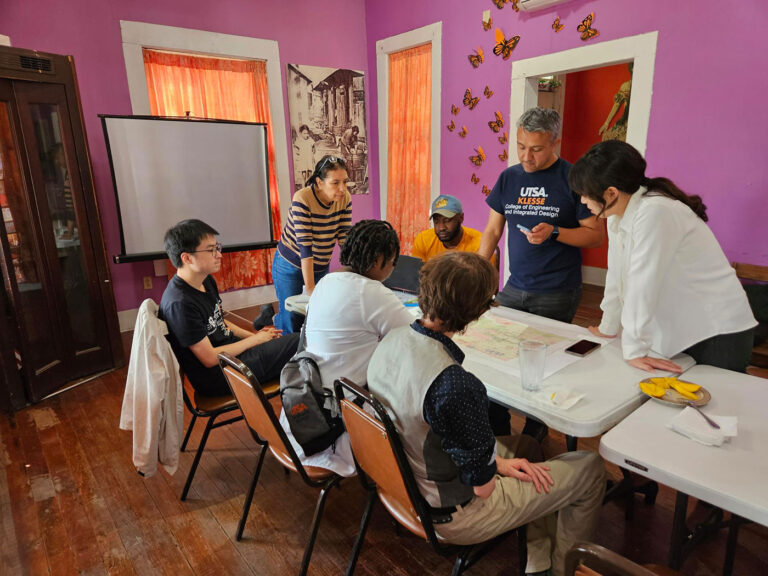 Several people gather around a table to conduct a meeting.