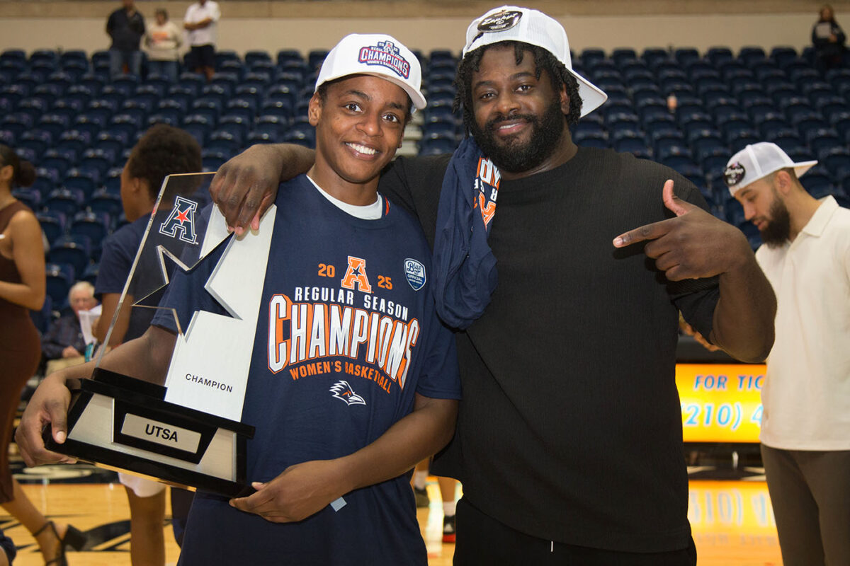 Jordyn Jenkins and Cameron Miles pose for a photo with the conference championship trophy.