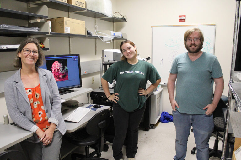 Three people side together in a lab.