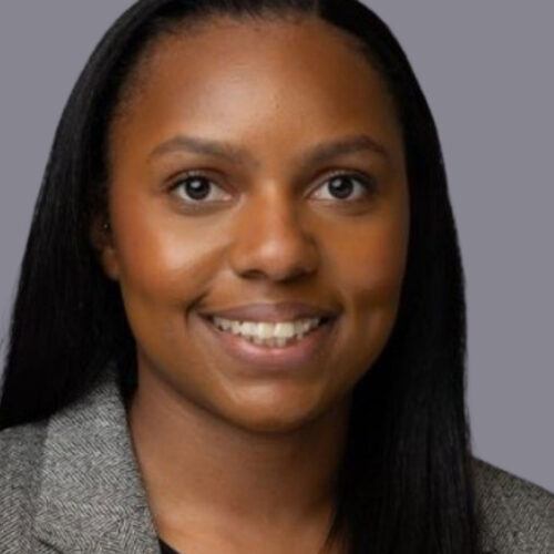 Woman in grey blazer jacket and black shirt.