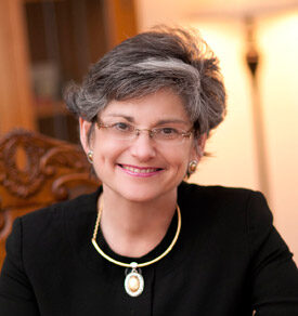 A woman with short grey hair in a black dress.