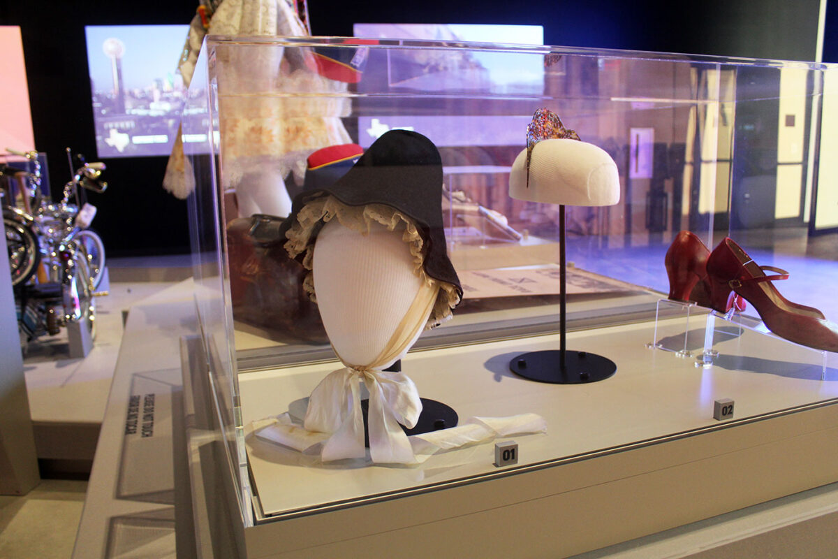 A black bonnet, hair accessory and red high heels on display at the Common Threads exhibit at the Institute of Texan Cultures.