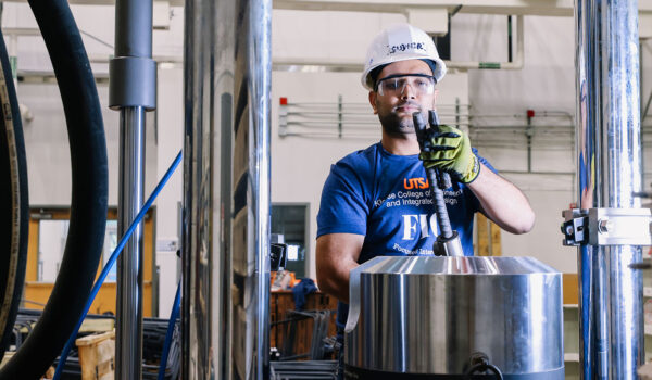 A construction science and management student works on a task with rebar