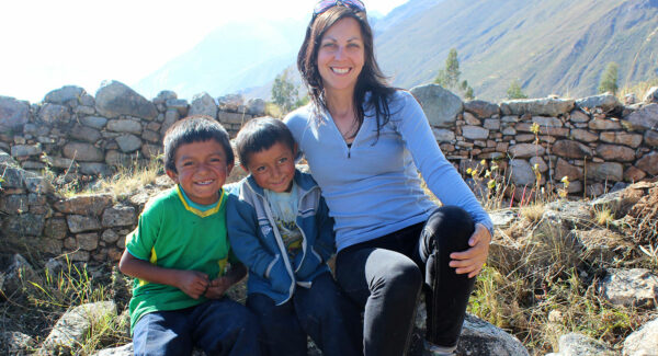Rebecca Bria with two children in mountain setting near archaeology site