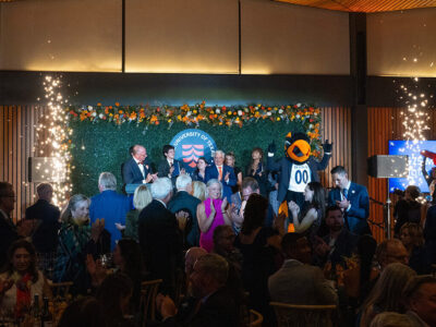 People stand on stage as sparklers go off alongside the stage.