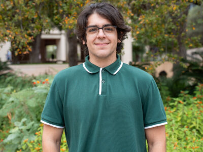 A man in a green polo shirt smiles at the camera.
