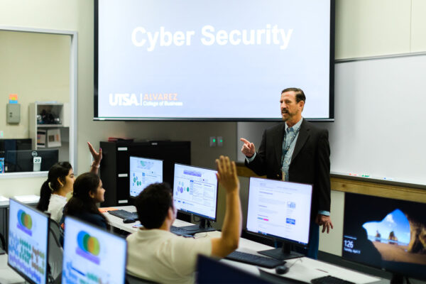 An instructor fields questions from students in a UTSA computer lab