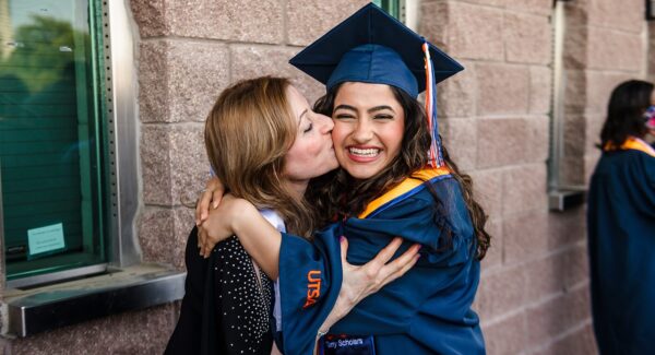 Two women hug each other.