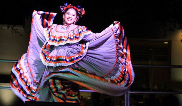 A ballet folklorico dancer shows off her colorful dress