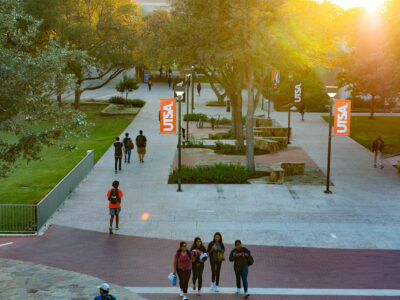 students walking on UTSA campus at sunset