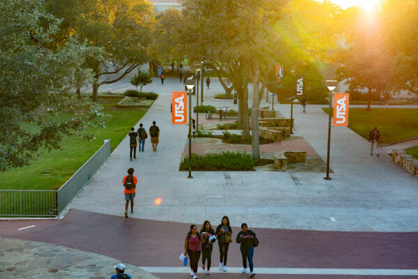 students walking on UTSA campus at sunset