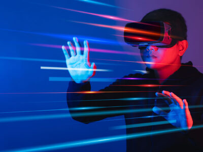 A man holds his arms out as he wears a virtual reality headset.