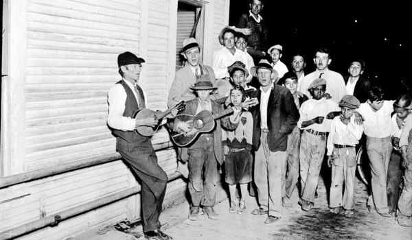 Spectators watch two musicians at San Antonio's Haymarket Plaza in January 1933.
