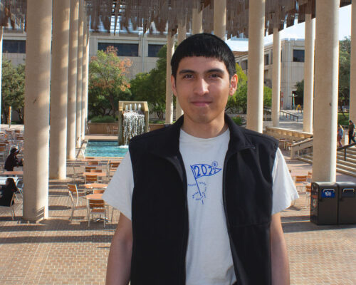 Hezron Perez poses for a photo in front of the Sombrilla Plaza on the UTSA Main Campus.