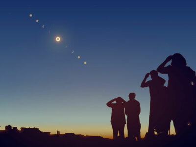 Group of people look up at sky to view eclipse.