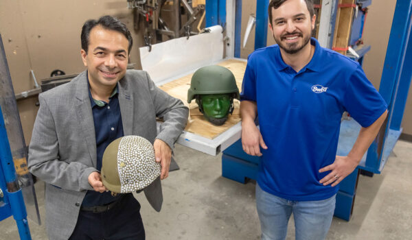 UTSA’s Morteza Seidi and SwRI’s Daniel Portillo holding military helmets